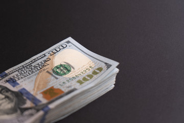 Close-up. Pack of hunred dollar bills on black background