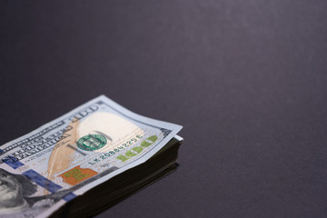 Pack of hunred dollar bills in the dark