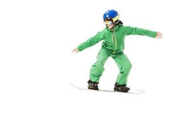 Preteen boy in green ski suit and blue helmet snowboarding isolated on white