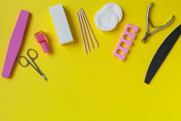 Top view of manicure tools on yellow background