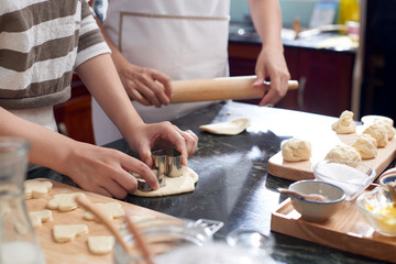 Hands of mother and daughter making sweet cookies for Christmas celebration