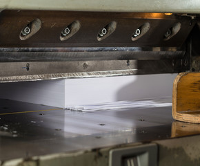 Front view of a paper guillotine in commercial printing industry. Hydraulic industrial guillotine.