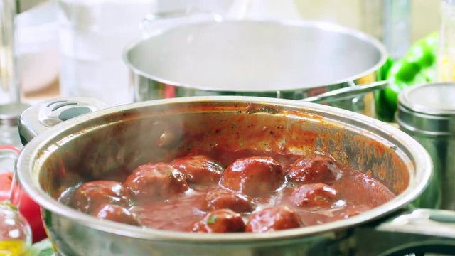 Preparing meatballs in tomato sauce with spaghetti pasta