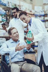 Obraz premium Man buys a mineral water in pharmacy