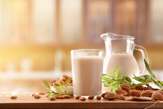 Alternative milk of almonds on wood table in rustic kitchen