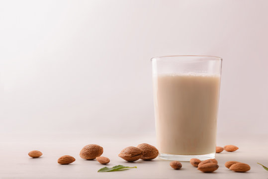 Healthy nutrition with almond drink in glass on white background