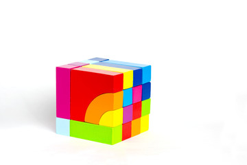 Obraz premium Colored wooden blocks, cubes, build on a light white background.A cube of colored wooden details