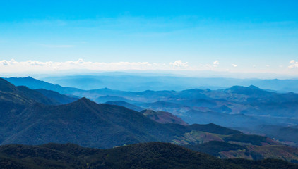 Obraz premium The mountains and forests with blue sky and white clouds at the peak of Inthanon national park (park name) in Chiang Mai province , Thailand in a sunny day. 