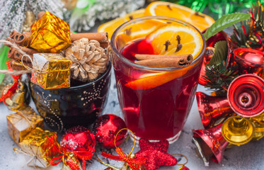 Hot wine (mulled wine) with spices on wooden background.