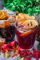 Hot wine (mulled wine) with spices on wooden background.