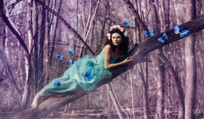 A girl among butterflies in a fairy-tale forest, in a dress