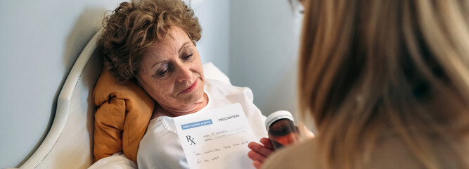 Female doctor giving a prescription to female senior patient