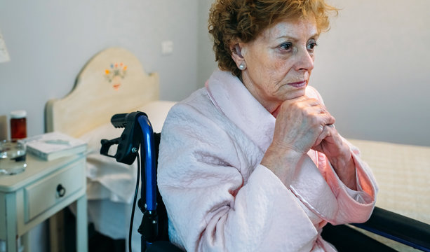Senior woman in a wheelchair alone in a room
