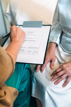 Female doctor filling out a questionnaire to a senior patient