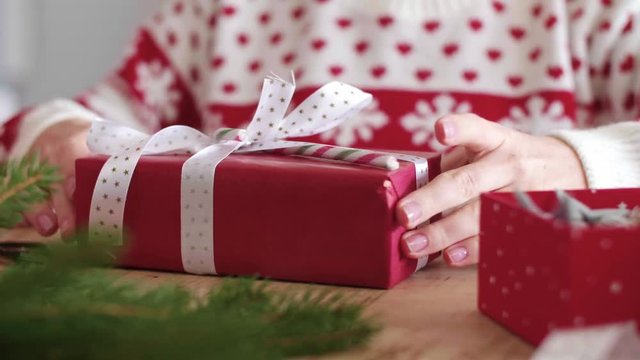 Close up of woman's hands wrapping the christmas gifts