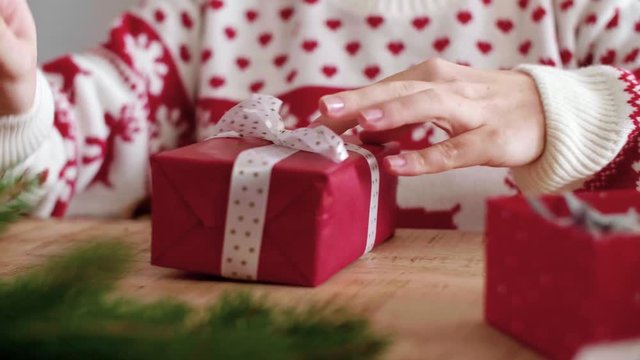 Close up of girl's hands decorating the christmas present