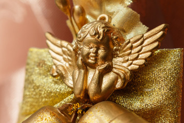 close-up of golden cherub figure with two jingle bells. Elegant christmas decoration