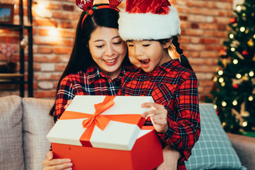 sweet family opening big gift box on boxing day