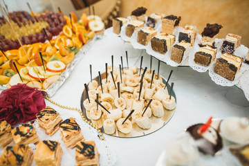 Delicious sweets on wedding candy buffet with desserts, cupcakes