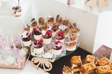 Fototapeta na wymiar Delicious sweets on wedding candy buffet with desserts, cupcakes