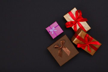 Gift boxes with ribbons on black background.