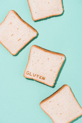 top view of messy spilled bread slices with burned gluten sign on blue surface