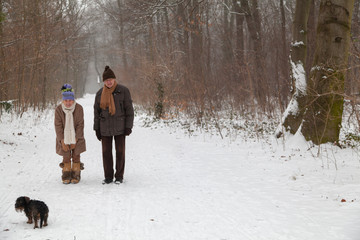 Fototapeta na wymiar Altes Paar Senioren im Winter ruft Hund