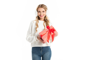 Fototapeta premium beautiful smiling young woman in winter outfit holding gift isolated on white