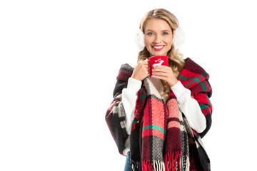 beautiful smiling woman in warm blanket holding cup of coffee isolated on white