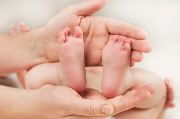 Obraz na płótnie Canvas Parent holds gentle little feet in a newborn baby
