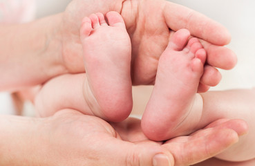 Obraz na płótnie Canvas Parent holds gentle little feet in a newborn baby