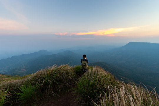man traveller tourism photographer standing  on top of a cliff mountain during sunset - landscape sunset Thailand