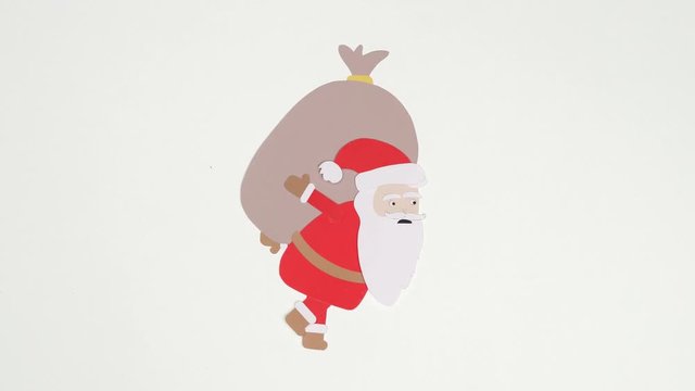 Santa Claus carrying heavy gift bag on his back. Stop motion cutout paper animation loop.