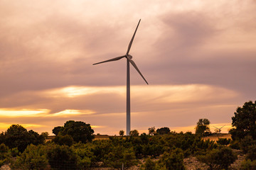 Wind power windmills and a beautiful sunset landscape. Clean and ecological energy being generated...