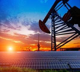 Clean power energy concept,Oil pump with solar panels and the sunset
