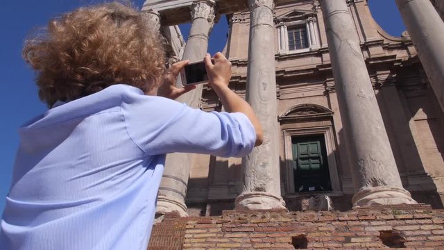 Female Tourist Taking Picture of Ancient Ruins Using Smartphone