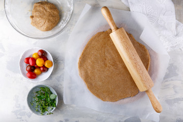 Ingredients for vegetable galette – dough, tomato, herbs.