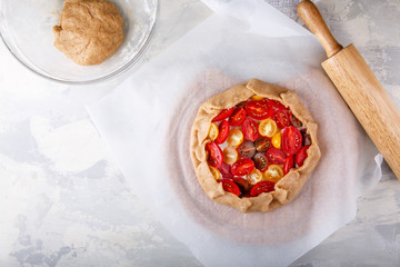 Ingredients for vegetable galette – dough, tomato, herbs.
