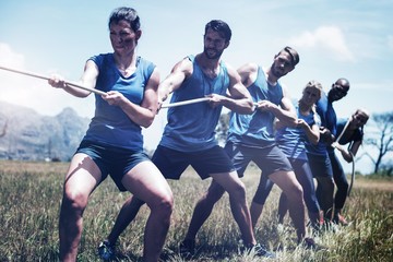 People playing tug of war during obstacle training course