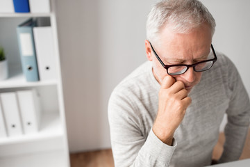 old age, problem and people concept - close up of senior man in glasses thinking