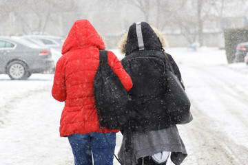 teenagers going from school on heavy snow
