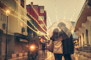 Couple in love on the street on a rainy day. Friends walking down the street