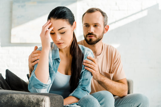 man emracing and trying to console depressed wife after arguing