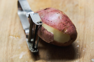 sliced raw potatoes and a knife on a wooden chopping Board
