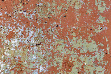 Background of rusty metal wall covered with paint peeling off