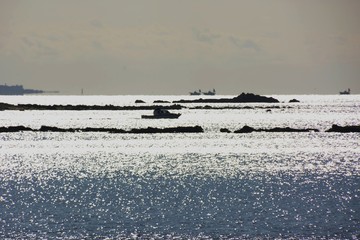 Shining of the sea surface and rocky silhouette