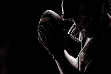 American football player standing with rugby helmet and ball