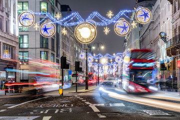 London im Winter bei Nacht: weihnachtlich geschmückte Einkaufstraße mit vorbeifahrenden Bussen
