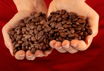 WOMAN WITH HANDFUL OF COFFEE BEANS