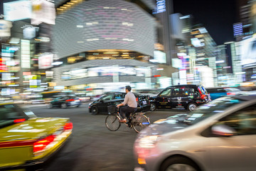 Tokyo, Japan - A local riding a bicycle through the traffic in downtown Tokyo in Japan